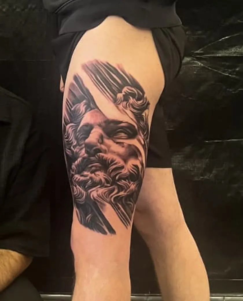Olympiër: zwart-grijze tattoo op de dij