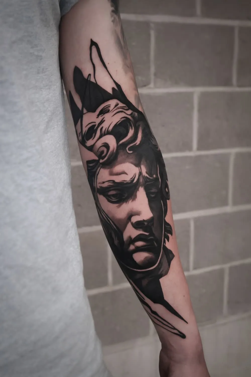 Standbeeld: zwart-grijze tattoo op de onderarm