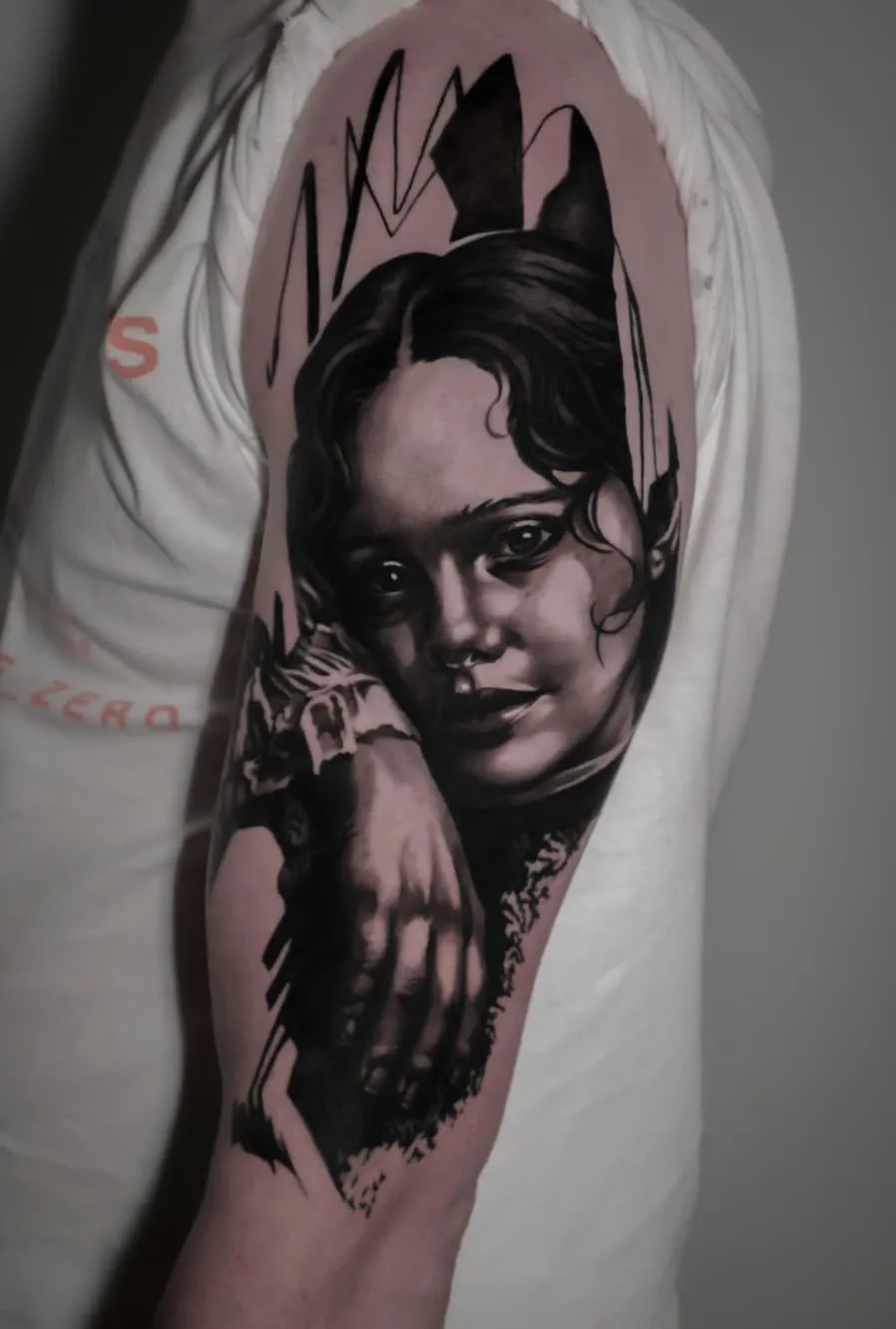 Portretstudie: zwart-grijze tattoo op de bovenarm