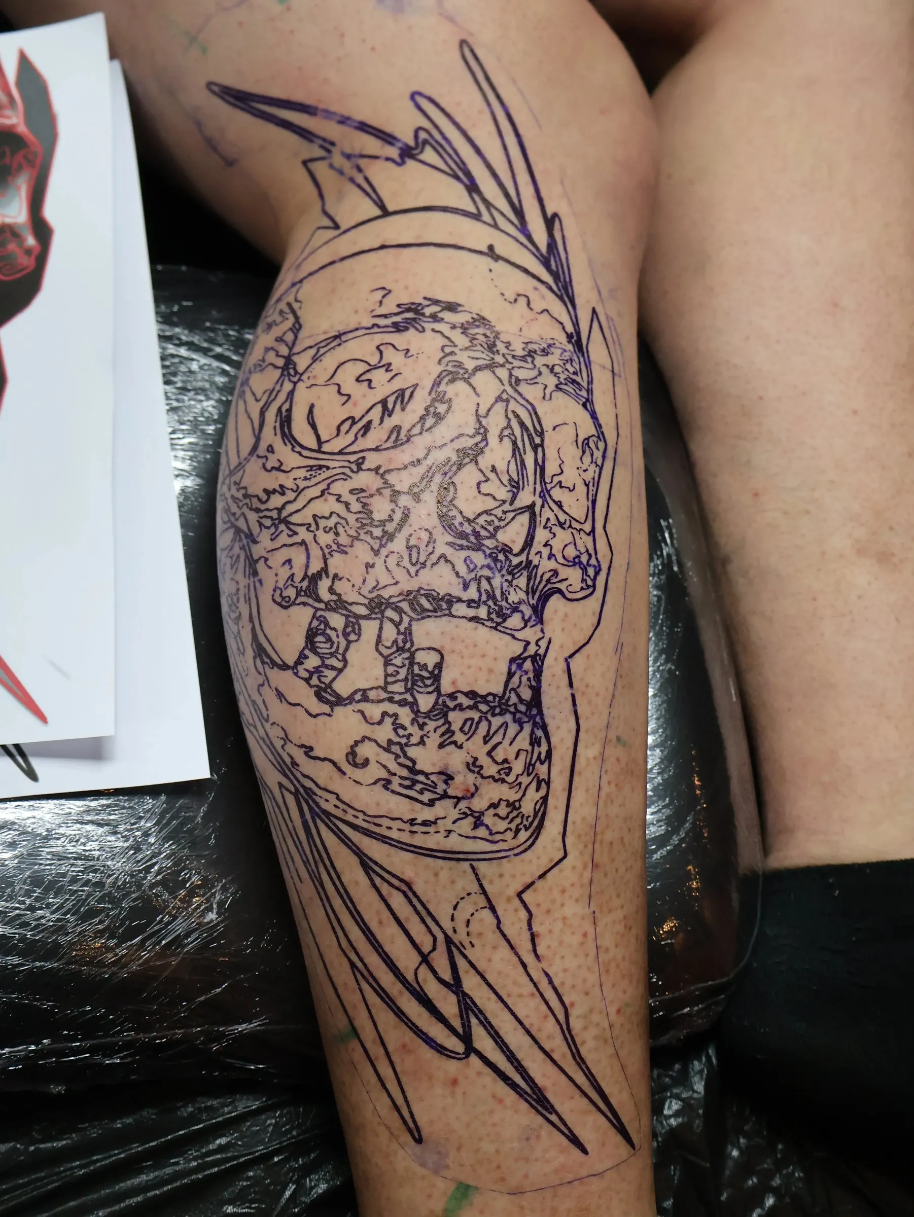 Form in chaos: the purple stencil of the skull and the abstract lines on the calf, ready to be tattooed
